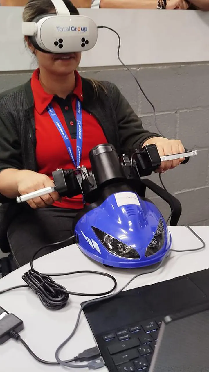 Trabajadora conduce el simulador de moto con gafas de realidad virtual